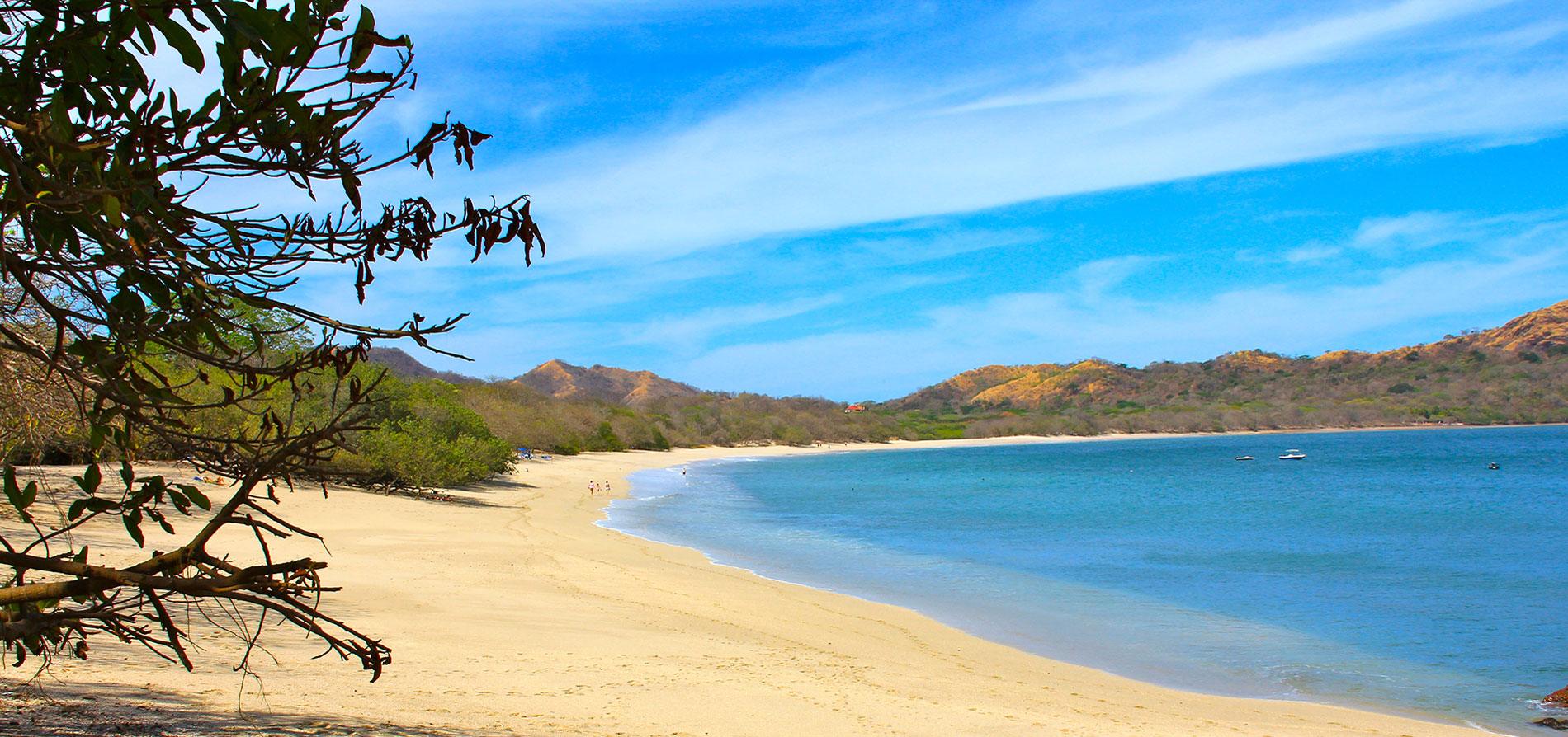 Brasilito beach on Costa Rica's Gold Coast — pale sand, turquoise bay, and dry-forest hills